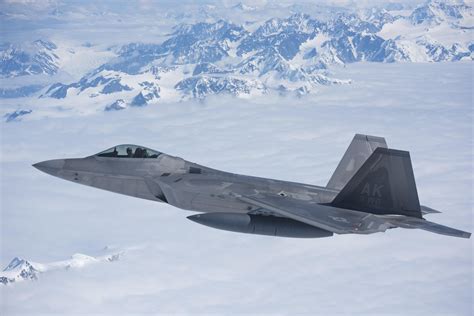 A U.S. Air Force F-22A Raptor stealth fighter jet "escorts the 176th Wing, Alaska Air National ...