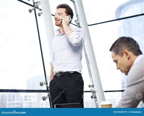 Business Person Talking On Cellphone In Office Stock Image - Image: 65540107