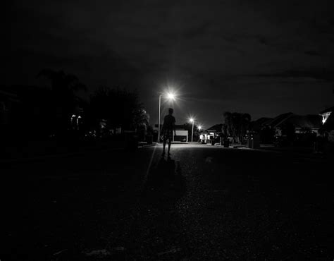 Free Photo | Boy walking alone at night under the street lights