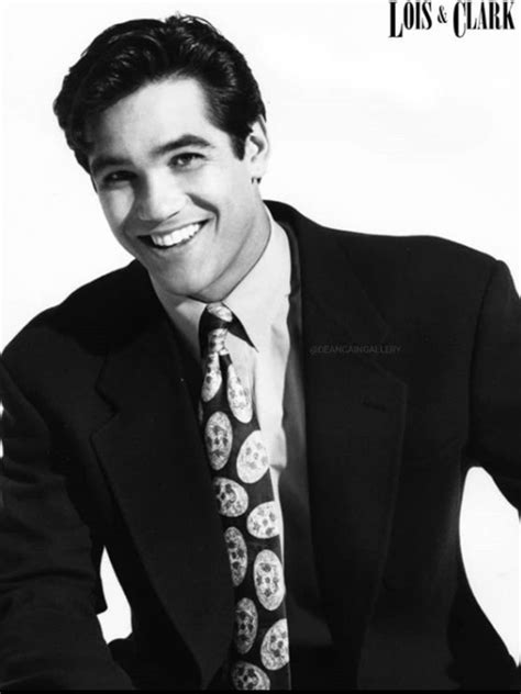 a man wearing a suit and tie with skulls on it's lapel smiling at the camera