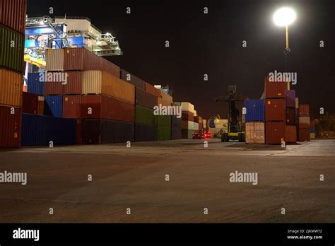 operation of container terminal at night. Unloading container ship at ...