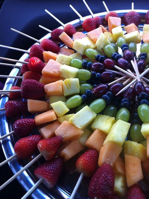 an assortment of fruits arranged on skewers in a circular arrangement with strawberries, grapes ...