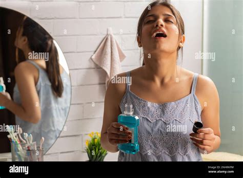 Woman gargling with mouthwash in bathroom Stock Photo - Alamy