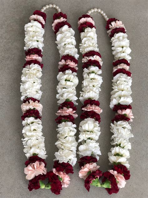 This beautiful garland has white, maroon and pink carnations adorned by ...