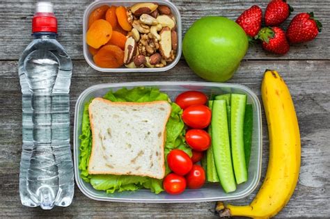 Loncheras saludables con sándwich y verduras frescas, botella de agua ...