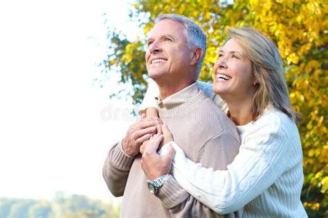 an older couple embracing each other in the park royalty images and clippings are available for