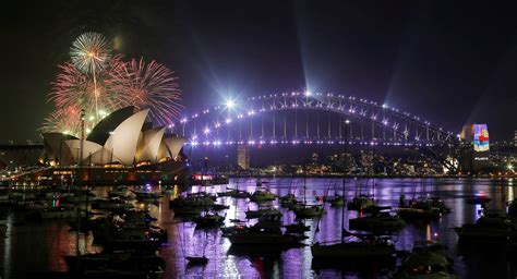 Fireworks explode over the Sydney Opera House and Harbour Bridge during an early evening display ...