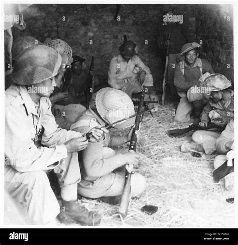 EIGHTH ARMY : GURKHA PATROL - Gurkhas at Company HQ clean up their weapons before setting out on ...