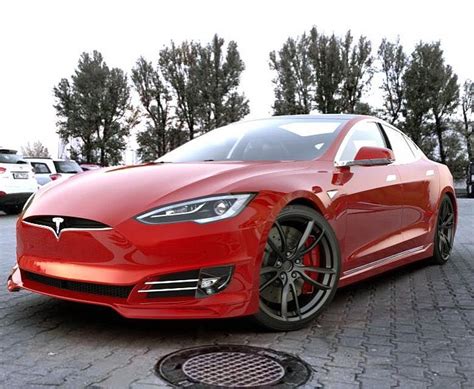 a red tesla model s is parked on the street