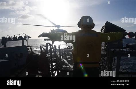 USS Curtis Wilbur flight deck crew signalling to MH-60 Seahawk ...