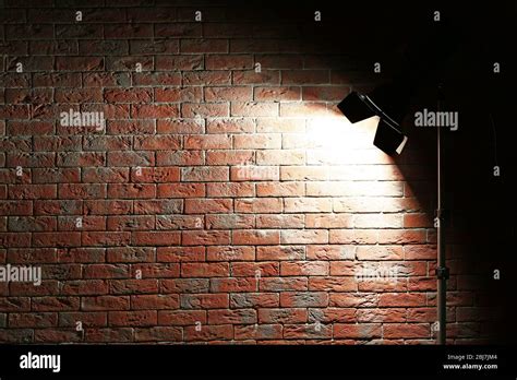 Studio light flash on brick wall background Stock Photo - Alamy