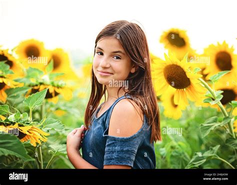 Happy tween girl in a sunflower field Stock Photo - Alamy