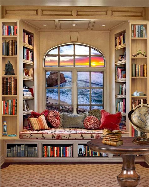 a living room filled with furniture and bookshelves next to a window overlooking the ocean