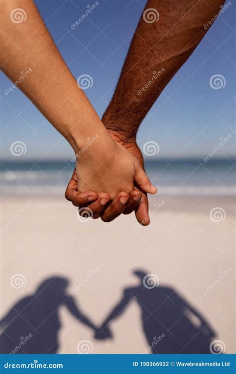 Couple Holding Hands on Beach in the Sunshine Stock Photo - Image of leisure, ocean: 150366932