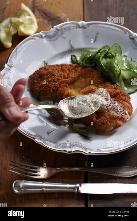 Viennese schnitzel with a cucumber salad Stock Photo - Alamy