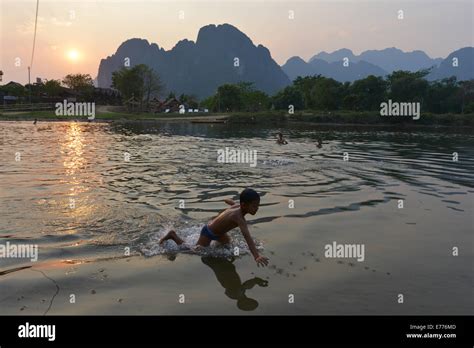 Vang Vieng, Laos - March 3, 2014: Children bathing in the river in Vang Vieng. Laos Stock Photo ...