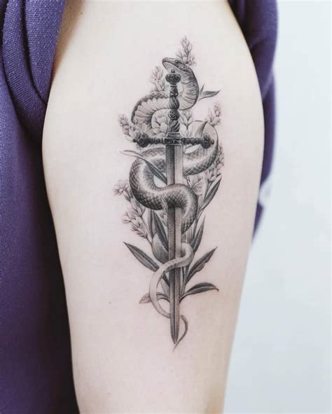 Micro-realistic snake and sword tattoo located on the