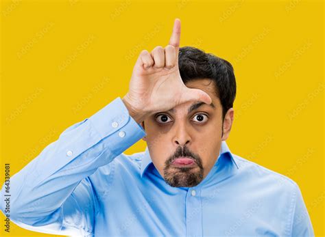 Bully guy giving Loser hand gesture on yellow background Stock Photo | Adobe Stock