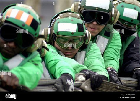 US Navy Flight deck crew members conduct an aircraft barricade rigging ...