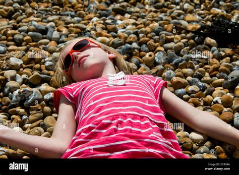 young girl sunbathing on a pebble beach Stock Photo - Alamy