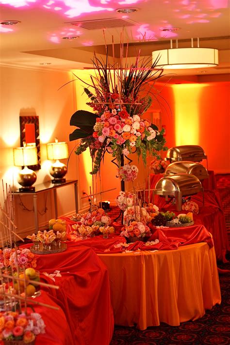 the table is covered with red cloths and flowers