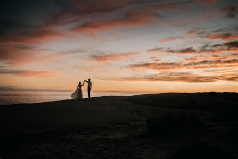 Silhouette of a Romantic Couple Standing on the Beach during Sunset · Free Stock Photo