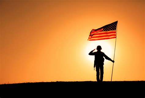 USA Soldier with flag saluting on sunset horizon - WINDFM - 92.5 Gainesville 95.5 Ocala
