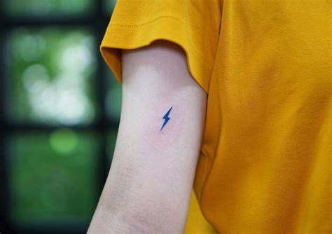 Blue lightning bolt tattoo located on the inner arm.