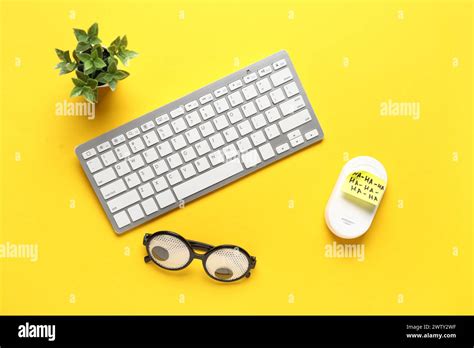 Funny glasses, sticky note, computer keyboard and mouse on yellow ...