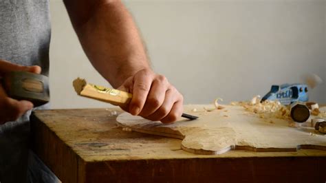 Luthier working on the top of a bowed instrument with a chisel 34220522 ...