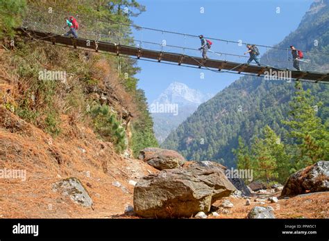 Trekkers crossing a suspension bridge over the Dudh Kosi river Stock Photo - Alamy