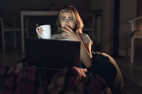 Premium Photo | A young woman sits at home alone and watches a horror movie