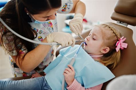 Premium Photo | Little baby girl at dentist chair