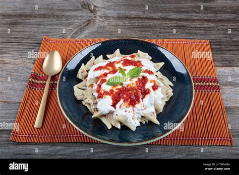 Plates of traditional Turkish food. Turkish Ravioli (Mantı) with yoghurt and tomato sauce Stock ...