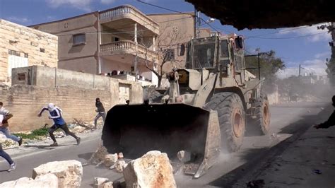 Israeli army bulldozer pushes boulders at high speed towards protesters ...