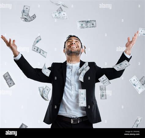 Not he who has much is rich. Studio shot of a well dressed man tossing ...