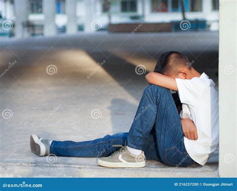 Young Boy Sitting Alone and Sad at the School. Stock Photo - Image of ...