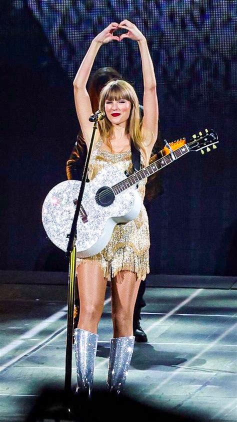 taylor swift performing on stage with her guitar