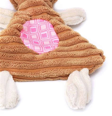 a brown teddy bear laying on top of a pile of white towels and mitts