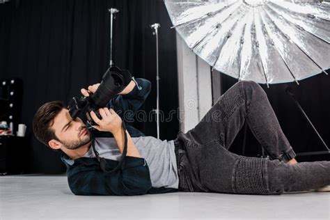 Handsome Young Photographer Lying and Using Photo Camera Stock Image ...