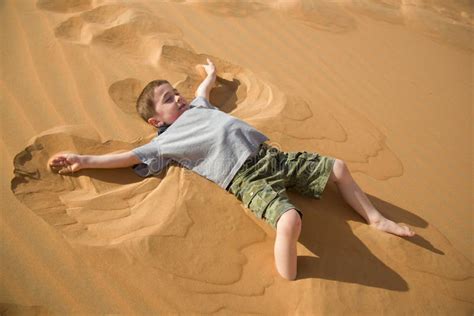 Little Boy Makes Sand Angel In Desert Stock Photo - Image of desert ...