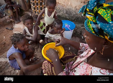 Children watch while their mother cooks food in a slum in Bamako, Mali ...