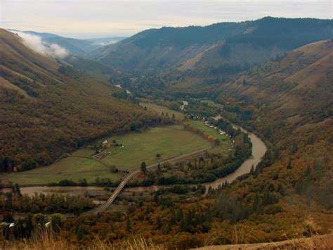 an aerial view of a valley and river surrounded by mountains in the ...