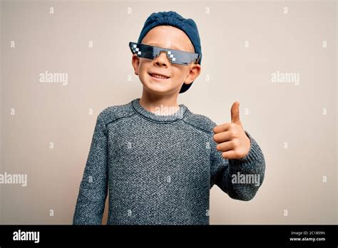 Young little caucasian kid wearing internet meme thug life glasses over isolated background ...