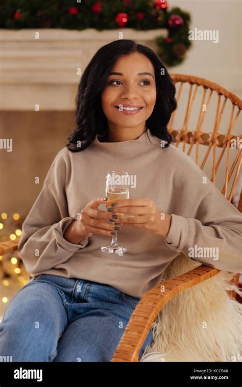 Pretty woman sitting in rocking chair with glass of champagne Stock Photo - Alamy