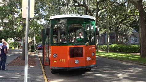 SAVANNAH, GEORGIA/USA - OCTOBER 23, 2014: Old Town Trolley tour departs from stop at city square ...