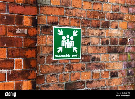 Assembly meeting point sign on wall for fire safety Stock Photo - Alamy