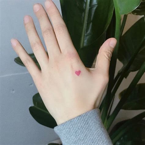 Tiny red heart tattoo on the hand - Tattoogrid.net