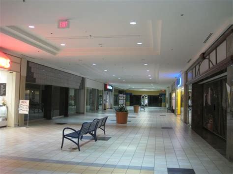 an empty shopping mall with benches and planters