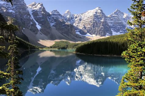 the mountains are reflected in the blue water